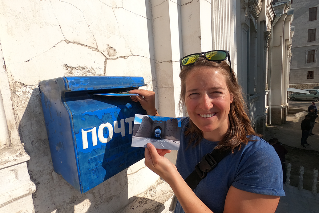Rebecca schiebt die Postkarten in ein Uzbekistan Briefkasten
